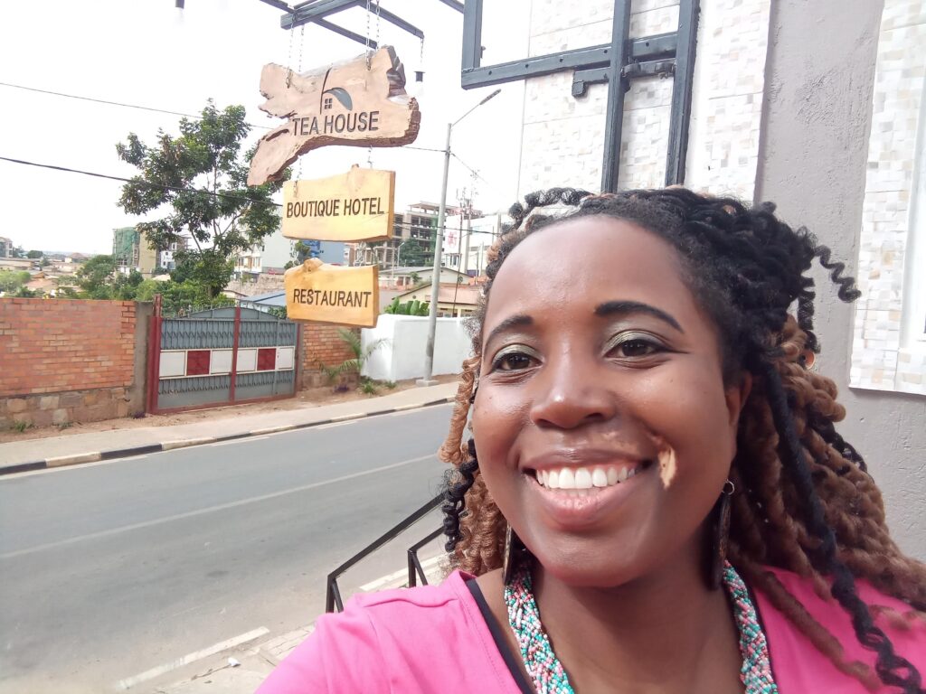 Sarah infront of a hotel in Rwanda while traveling solo